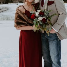 a man and woman standing next to each other in the snow