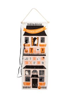 a halloween house hanging on a wall with the numbers and date in front of it