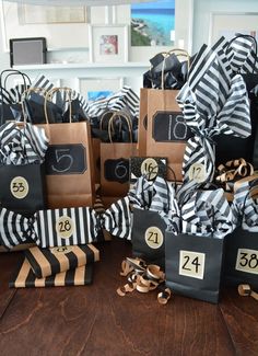 black and white gift bags with numbers on them sitting on a table in front of other packages