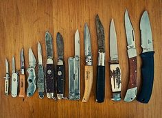 many different types of knives lined up in a row on a wooden table with the words man cave written below them