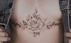 a woman's stomach with flowers and leaves tattooed on the side, behind her