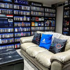 a living room filled with furniture and lots of video game memorabilia on the wall behind it