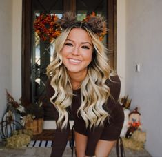 a woman with long blonde hair is smiling for the camera