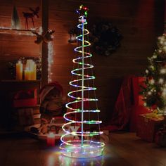 a lighted christmas tree sitting on top of a wooden floor