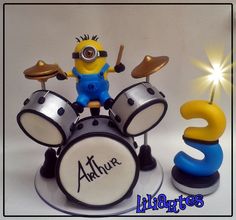 a minion is sitting on top of a drum set