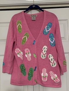 This vintage Timberlea cardigan is a unique addition to your wardrobe. With a pink color and 3/4 sleeves, it is perfect for the beach or a casual day out. The cardigan features hidden buttons, beaded and embroidered accents, and a floral design. Made of a combination of ramie and cotton materials, this sweater is comfortable to wear in the fall, winter, or spring seasons. The size of the cardigan is medium and it has a regular fit. The Timberlea brand is known for its quality and this vintage ca Pink Summer Sweater, Pink Embroidered Fitted Cardigan, Fitted Embroidered Pink Cardigan, Fitted Pink Embroidered Cardigan, Pink Embroidered Long Sleeve Cardigan, Vintage Beach Cardigan For Spring, Vintage Spring Beach Cardigan, Vintage Pink Cardigan For Spring, Spring Vintage Cardigan For Beach