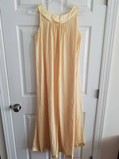 This is a vintage Gossard Artemis nightgown. This piece is sleeveless and is a very pretty shade of pale yellow. There are floral appliques and a satin hem and trim. This piece is labeled a size small, but I think it can fit a larger size than that. There is a small speck and a minor tug in this nightgown. You can see this in the images. The price reflects this. The measurements are as follow: (All measurements taken flat.) Please compare the measurements to your own well fitting clothes as I do Sleeveless Nightgown, Fitting Clothes, Women's Nightgowns, Nightgowns, Floral Applique, Pale Yellow, Appliques, Night Gown, Sleeveless Dress