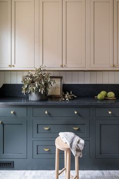 an image of a kitchen setting with blue cabinets and stools in the foreground