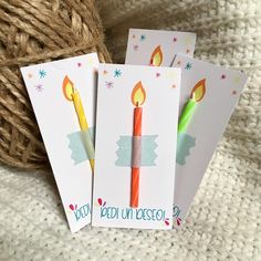 three birthday cards with candles on them sitting next to a ball of twine yarn