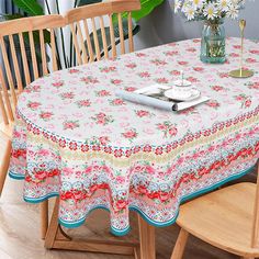 a dining room table covered with a pink and white floral print