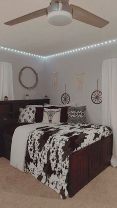 a bed room with a neatly made bed and a ceiling fan