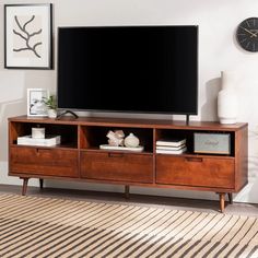 a flat screen tv sitting on top of a wooden entertainment center in a living room