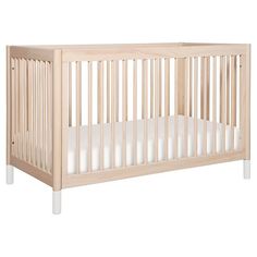 a wooden crib with white sheets on the bottom and sides, against a white background