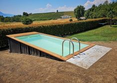 an empty swimming pool in the middle of a field