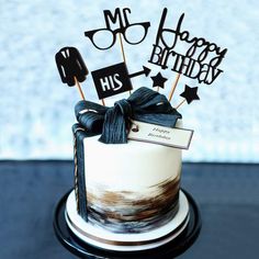 a birthday cake decorated with black and white decorations