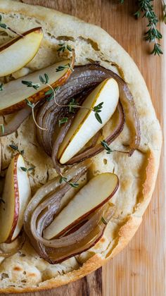 an apple and onion tart with herbs on top