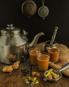 there is a tea pot and two cups with some food on the table