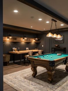 a pool table in the middle of a room with two lamps on either side of it