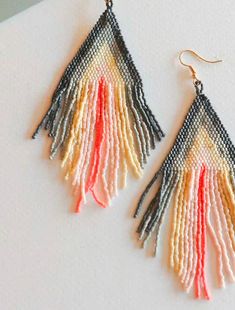 The Janice Gray and Coral Fringe Dangle Beaded Earrings exude bohemian charm with their intricate gray and coral beadwork, accented by playful fringe dangles, offering a vibrant and stylish accessory for eclectic fashion statements. Bohemian Gray Beaded Jewelry, Gray Beaded Dangle Earrings, Bohemian Gray Dangle Earrings, Bohemian Gray Dangle Jewelry, Dangle Beaded Earrings, Grey And Coral, Bead Projects, Grey Beads, Fashion Statements