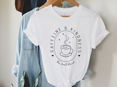 Get ready to brew up some smiles with our Caffeine and Kindness tee.  This tee features a minimalist design that proclaims your appreciation for the two best things in life: a good cup of coffee and a kind heart.  Ideal coffee lovers and for busy baristas who juggle espresso shots and smiles. Whether you're behind the counter, lounging at your favorite café, or out and about, you'll remind everyone that the best blend isn't just in your cup, but also in your heart. Coffee T Shirt, Coffee Shirt Ideas, Barista T Shirt, Coffee Tshirt Design, Trendy Coffee Color T-shirt With Screen Print, Coffee Cotton T-shirt With Screen Print, Barista Shirt, Coffee Cotton T-shirt With Text Print, Everyday Coffee T-shirt With Text Print