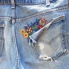 a pair of blue jean shorts with embroidered flowers on the back pocket and side pockets