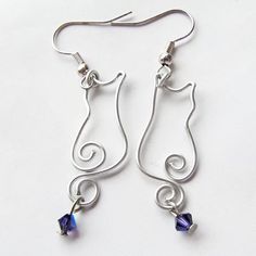 the earrings are made with silver wire and blue crystal beads