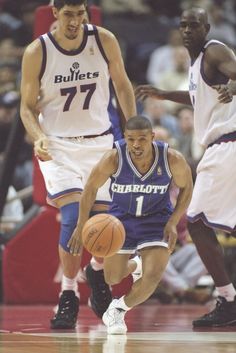 a basketball player dribbling the ball during a game with fans in the stands