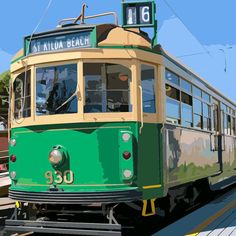 a green and yellow trolley car traveling down the tracks next to a train station sign