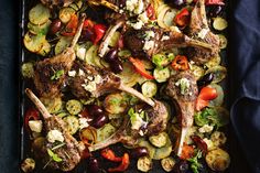 a tray filled with lamb chops and vegetables