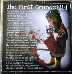 the first grandchild poem is displayed on a wooden plaque with red flowers and yellow rubber boots