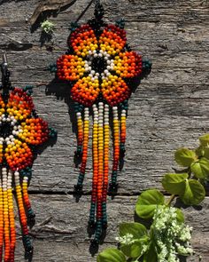 These beaded flower earrings are brought to you by the courtesy of the Huichol Tribe of Tepic, Mexico. We are blessed to be able to partner with them. Every purchased pair of earrings helps to support this tribe. * 100% handmade by a person who puts all their effort and dedication so that you have a product of the highest quality -Enjoy the details of this gorgeous set...including stainless steel hooks and bright yellow, orange, and white beads. -We are proud to share with you a little glimpse of the Huichol culture. They are amazing artists with exceptional skills. -These pairs of earrings are an artistic piece made with the highest quality for you to enjoy. -Through your purchase you are supporting artisans who make from this art their way of living -For more information about our partne Bohemian Orange Flower Beaded Earrings, Artisan Beaded Earrings For Festivals, Bohemian Flower Beaded Earrings For Gifts, Bohemian Orange Flower Beaded Necklace, Unique Beaded Earrings With Tiny Beads For Festivals, Artisan Hand-strung Beaded Earrings, Artisan Hand-strung Earrings For Gift, Bohemian Flower Shaped Beaded Earrings, Bohemian Flower Shaped Colorful Beaded Earrings