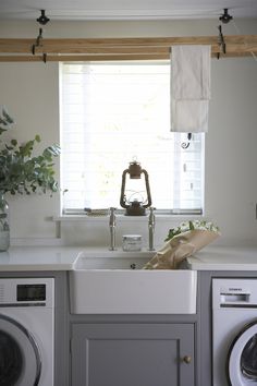 a washer and dryer sitting in a kitchen next to a window with blinds