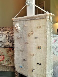 a wall hanging made out of burlap with earring hooks attached to it