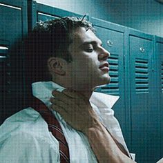 two men standing next to each other in front of lockers and looking at each other