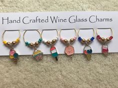 six wine glass charms with different designs on them