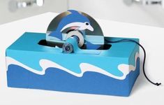 a blue box with a dolphin design on the front and sides, sitting on a table