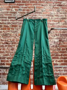 Mens 70s Green Psychedelic Pants with a Hint of Flare and Marigold Style Lines.  Amazing men's seventies green psychedelic pants cut with a hint of flare at the hem. Epic marigold style lines running up the front of the legs. Shorter style lines at the back of the hem. Contrasting marigold top stitching against this fantastic green. Front pockets and small back pockets with beautiful detail. Belt loops for your favorite seventies belt. Zipper fly with a snap button closure at the waist. The fabric is a non stretch blend with a slight sheen to it. These are statement pants for your psychedelic look. There is hem allowance for a longer inseam if you want to take the hem down and re hem. No tag. We do not know who made these incredible 70s pants. In perfect condition.  Measurements:  34" wais Retro Green Wide Leg Bottoms, Vintage Fitted Green Bottoms, Vintage Green Wide-leg Bottoms, Retro Fitted Green Bottoms, Green Retro Fitted Bottoms, Retro Green Full-length Bottoms, Fitted Retro Green Bottoms, Retro Full-length Green Bottoms, 70s Fashion Men