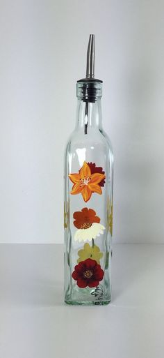 a glass bottle with flowers painted on it