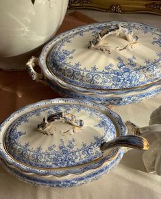 two blue and white dishes sitting on top of a table