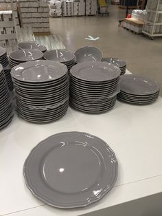 a table topped with lots of gray plates