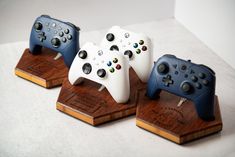 three nintendo wii game controllers on wooden bases