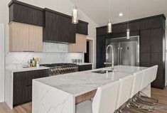 a large kitchen with marble counter tops and stainless steel appliances