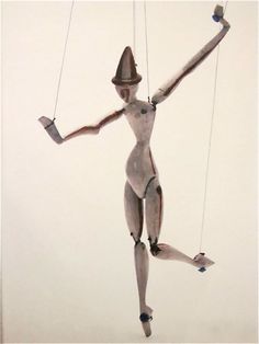 a woman is suspended on strings with her arms and legs spread out to the side