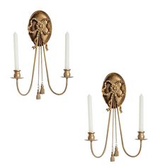 two wall sconces with candles attached to them