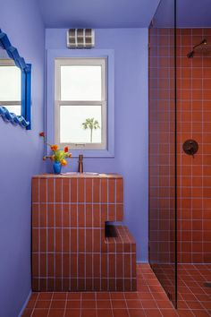 a bathroom with purple walls and tile flooring next to a sink, shower and window