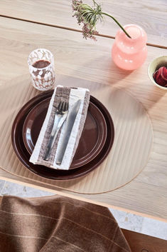 a table with plates, napkins and flowers on it is shown in this image