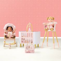 two dolls sitting next to each other in front of a baby crib and chair