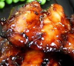 chicken wings with sauce and green peas on the side