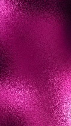 a shiny metallic surface that is pink and purple with some light reflecting on it's surface