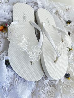 These beautiful flip flops are wrapped in white satin ribbon, and adorned with 3 white flowers on each side with a pearl in the center. Ribbon color is white, if you are needing other colors of ribbon or decoration please contact me and will be happy to accommodate you! All flip flops are handmade to order and the production time 1 to 2 weeks and then please allow additional time for shipping. Amazing for beach, weddings, flower girl or a fancy event, you choose! Please choose your size from the Elegant Beach Wedding Shoes For Spring, Adjustable Sandals For Spring Wedding, White Sandals For Beach Wedding In Spring, Pearl White Summer Wedding Shoes, Elegant Adjustable Flip Flops For Summer, White Sandals For Spring Wedding, White Sandals For Wedding In Spring, White Wedding Sandals For Spring, Elegant Adjustable White Wedding Shoes